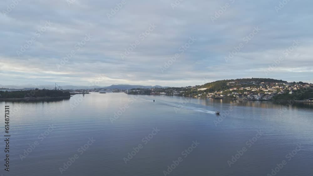 A speed boat creates a wake in the serene water of Stavanger Norway