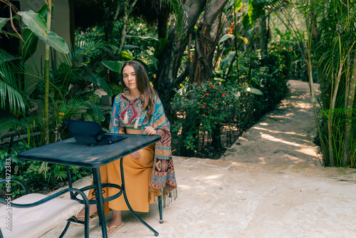 girl working on a computer in a tropical climate