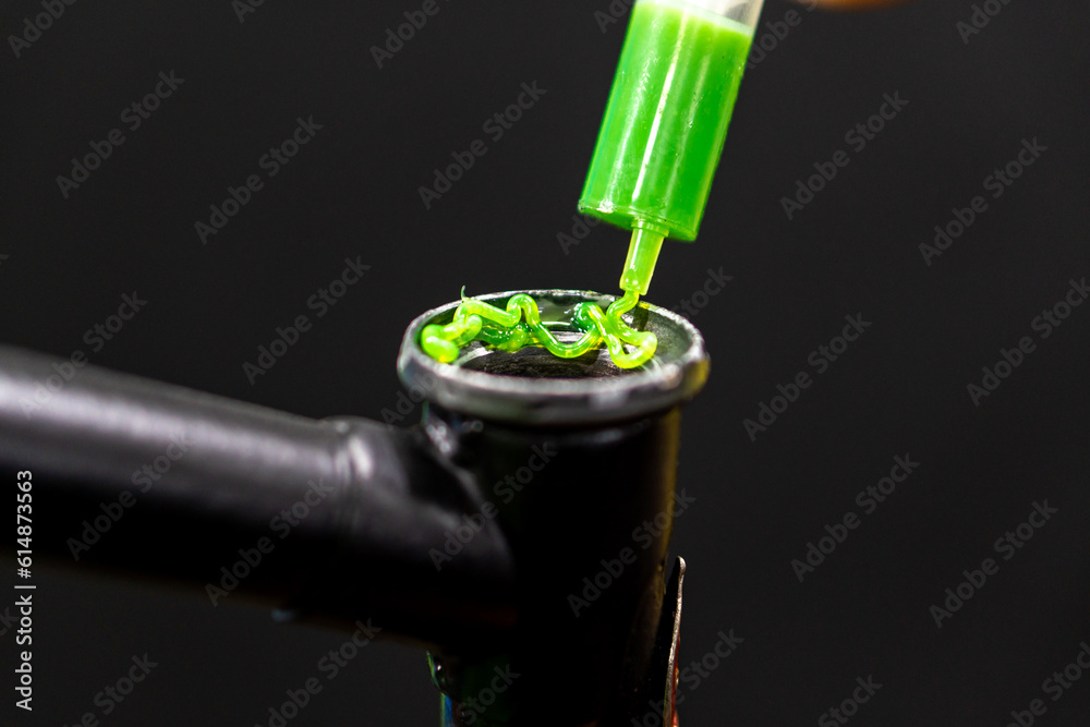 Lubrication of the steering column bearings of a road bike. A syringe