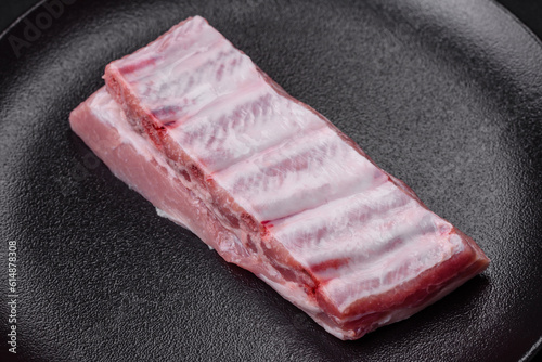 Raw pork ribs with meat with salt, spices and herbs