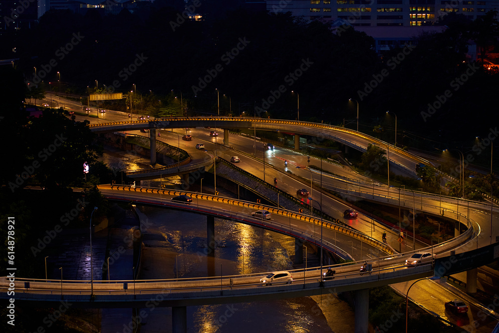 Obraz premium Night photo of a glowing multi-level road junction with heavy traffic. Roads in the metropolis