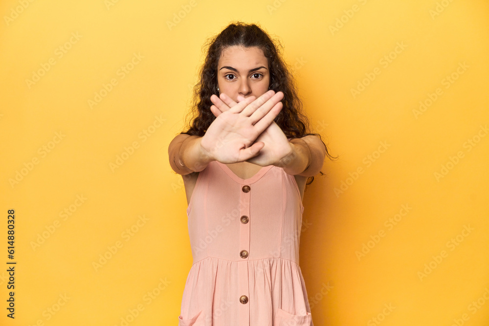 Young Caucasian woman, yellow studio background, doing a denial gesture Young Caucasian woman, yellow studio background, doing a denial gesture