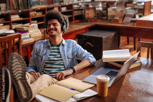 Student streaming music and studying in library.