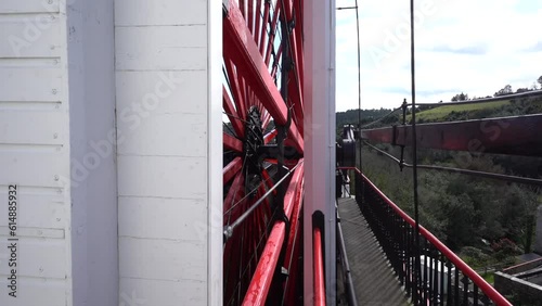 Laxey, Isle of Man - 01 April 2023: rotating red wooden spokes of the water-powered Laxey Wheel photo