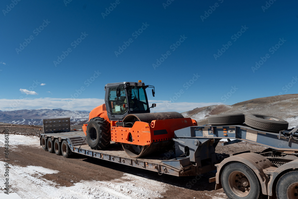 Mountain road leveler being transported by truck