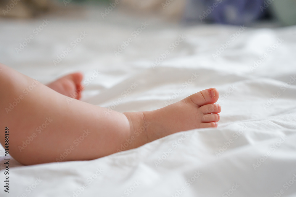 The legs of the baby's foot on a white sheet The legs of the baby's foot on a white sheet
