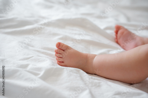The legs of the baby s foot on a white sheet
