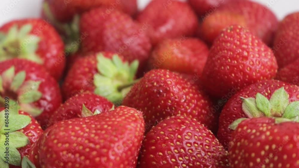 Closeup shot of beautiful tasty red strawberry lies on a white plate Closeup shot of beautiful tasty red strawberry lies on a white plate