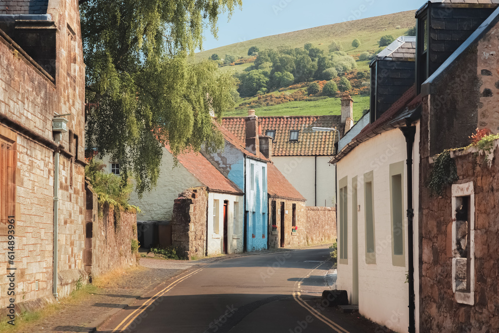 Quaint and charming country lane in the historic old town village of Falkland with countryside view of  the Lomond Hills on a sunny summer day in Fife, Scotland, UK.