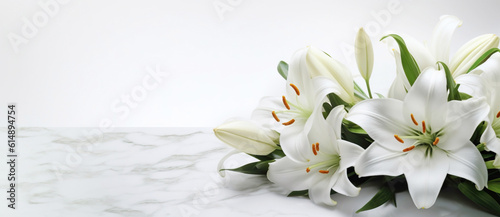 Beautiful white flowers, lilies , over marble background. Bouquet of flowers at cemetery , funeral concept.