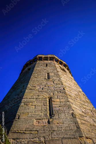A Castle tower reaching for the sky and showing its defensive structure.