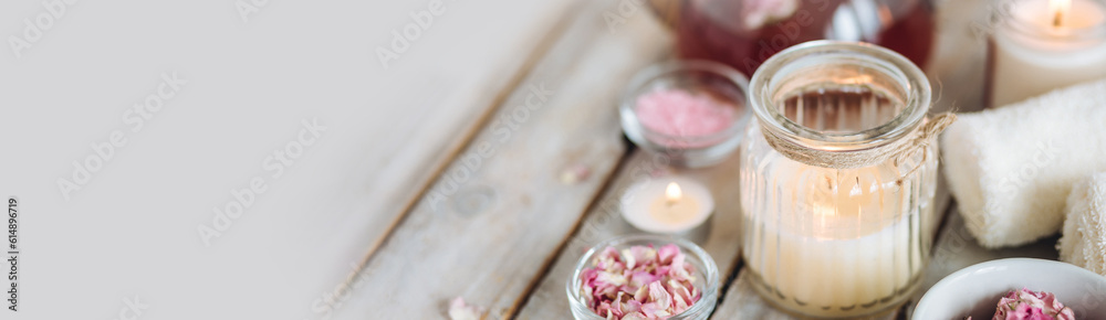 Aromatherapy. Bath salt, pure natural essential oils, floral rose extract. Spa treatment, skin care, relaxation with burning candles, herbal organic hot tea. Towel, wooden background banner copy space Aromatherapy. Bath salt, pure natural essential oils, floral rose extract. Spa treatment, skin care, relaxation with burning candles, herbal organic hot tea. Towel, wooden background banner copy space