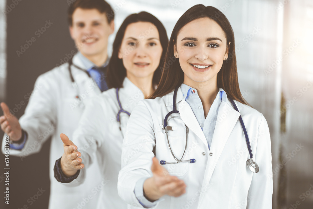 Doctors are standing as a team while offering their helping hands for shaking hand or saving people's life. Medical help, insurance in health care, best disease treatment and medicine concept Doctors are standing as a team while offering their helping hands for shaking hand or saving people's life. Medical help, insurance in health care, best disease treatment and medicine concept