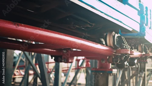 Close up of twisting red roller coaster in slow motion with sun reflections. Funfair and amusement park