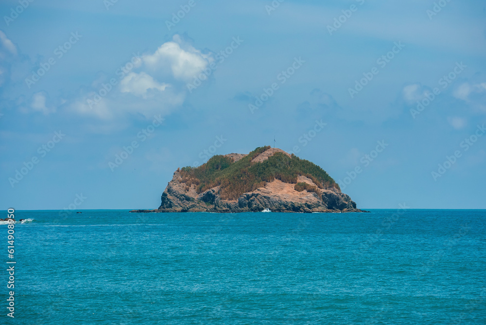 Scenic view of cliff in the middle beautiful seascape under blue sky during sunny day at Costa Rica, nature and travel concept