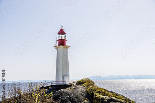 Stone lighthouse with a red top by the ocean