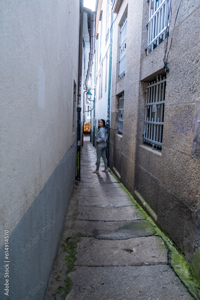 Santiago de Compostela, La Coruna, Galicia, Spain  - 12 June, 2023. Tourist walking in a narrow street at city center