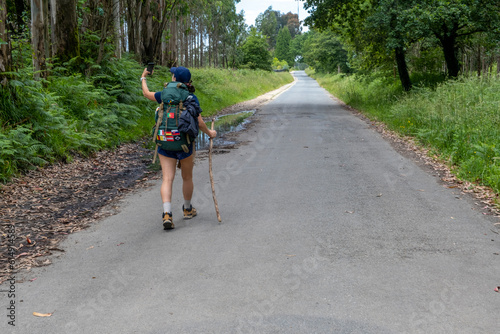 Young woman pilgrim taking a selfie on a trail of the way of saint james. Camino de Santiago photo