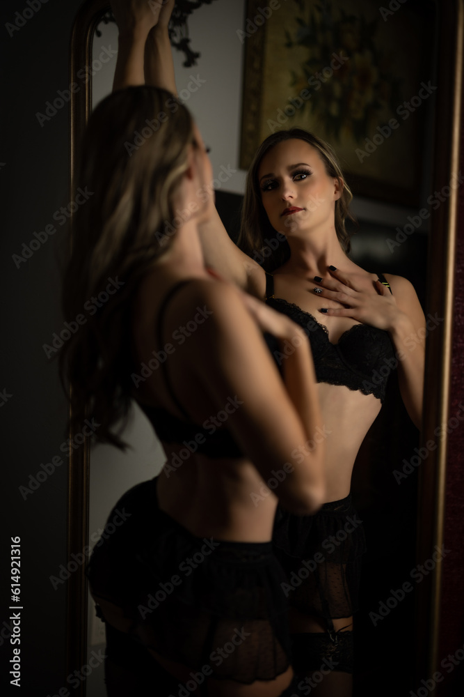 female standing by mirror and fireplace female standing by mirror and fireplace