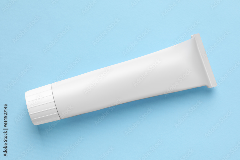 Tube of ointment on light blue background, top view. Space for text Tube of ointment on light blue background, top view. Space for text