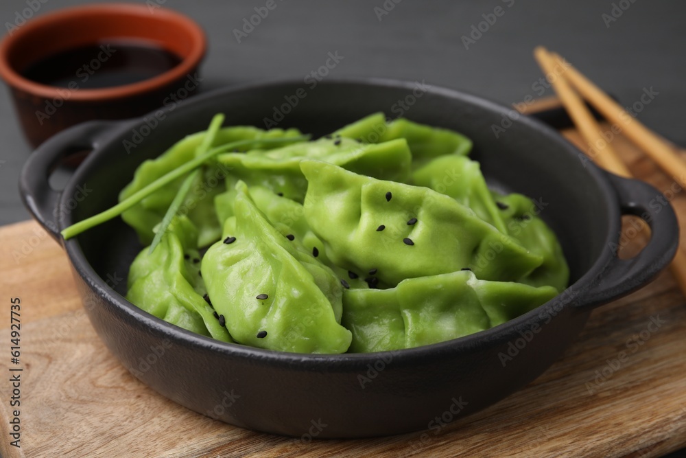 Delicious green dumplings (gyozas) and soy sauce on grey table, closeup Delicious green dumplings (gyozas) and soy sauce on grey table, closeup