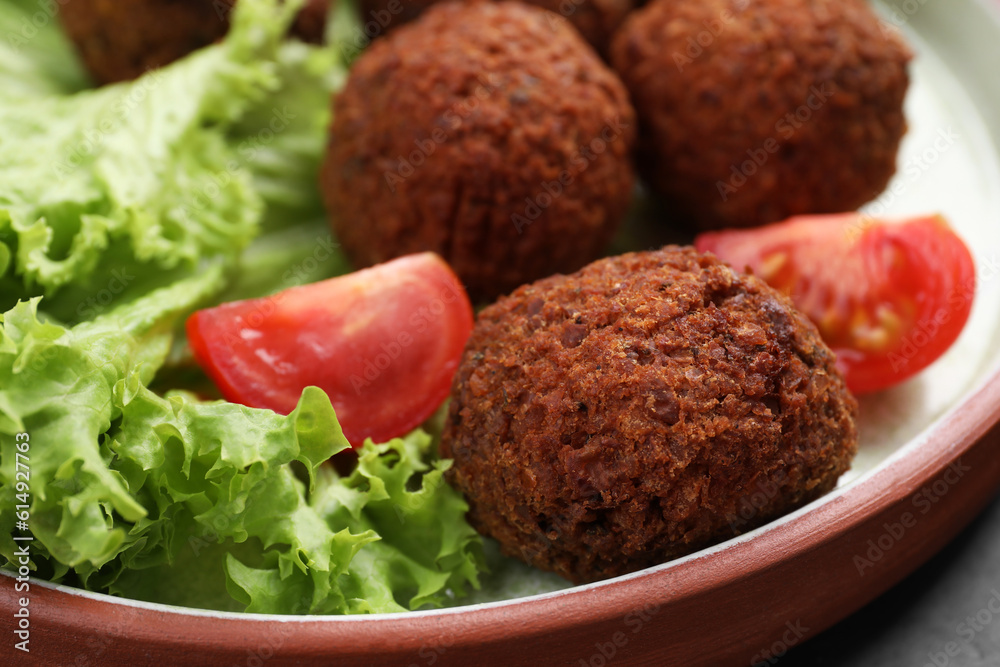 Delicious falafel balls, tomatoes and lettuce on plate, closeup. Vegan meat products Delicious falafel balls, tomatoes and lettuce on plate, closeup. Vegan meat products