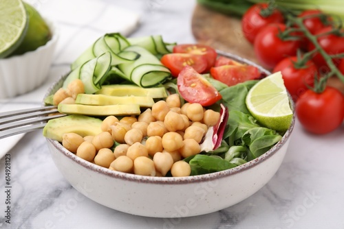 Tasty salad with chickpeas and vegetables on white marble table, closeup