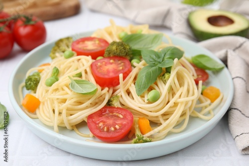 Plate of delicious pasta primavera and ingredients on white table, closeup