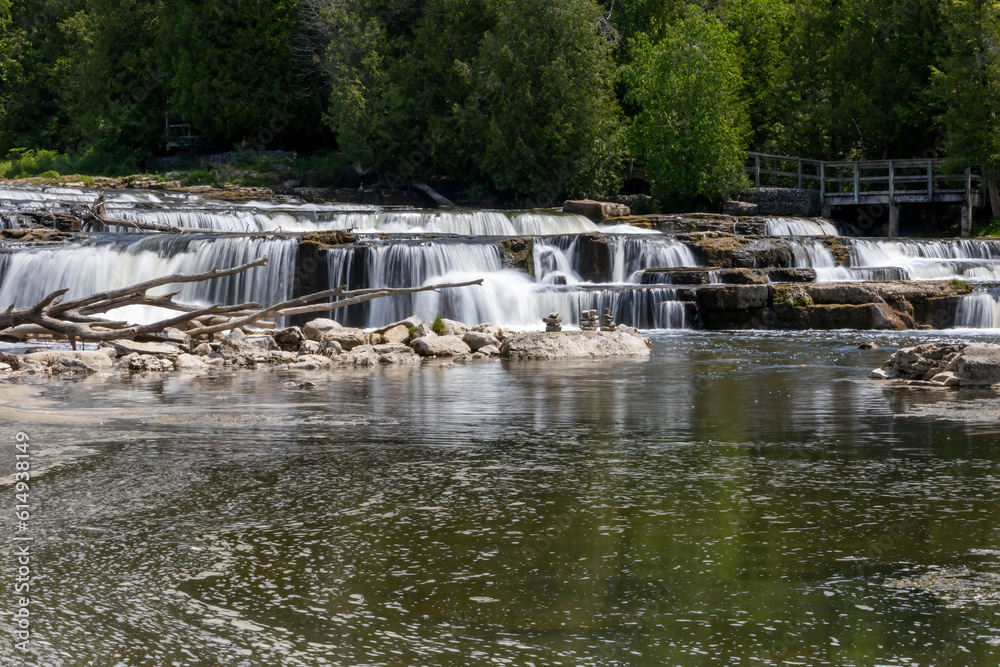 Obraz premium The milky waters of Sauble Falls at the south end of the Bruce Peninsula cascade over the rocks into the river.