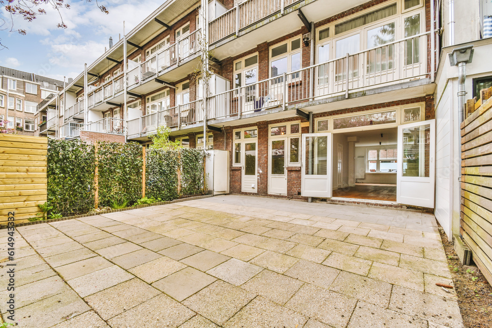 an outside area with some plants and buildings in the background, as seen from the ground looking up to the building