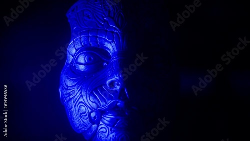 Steampunk robotic human face illuminated by neon blue light, loop photo