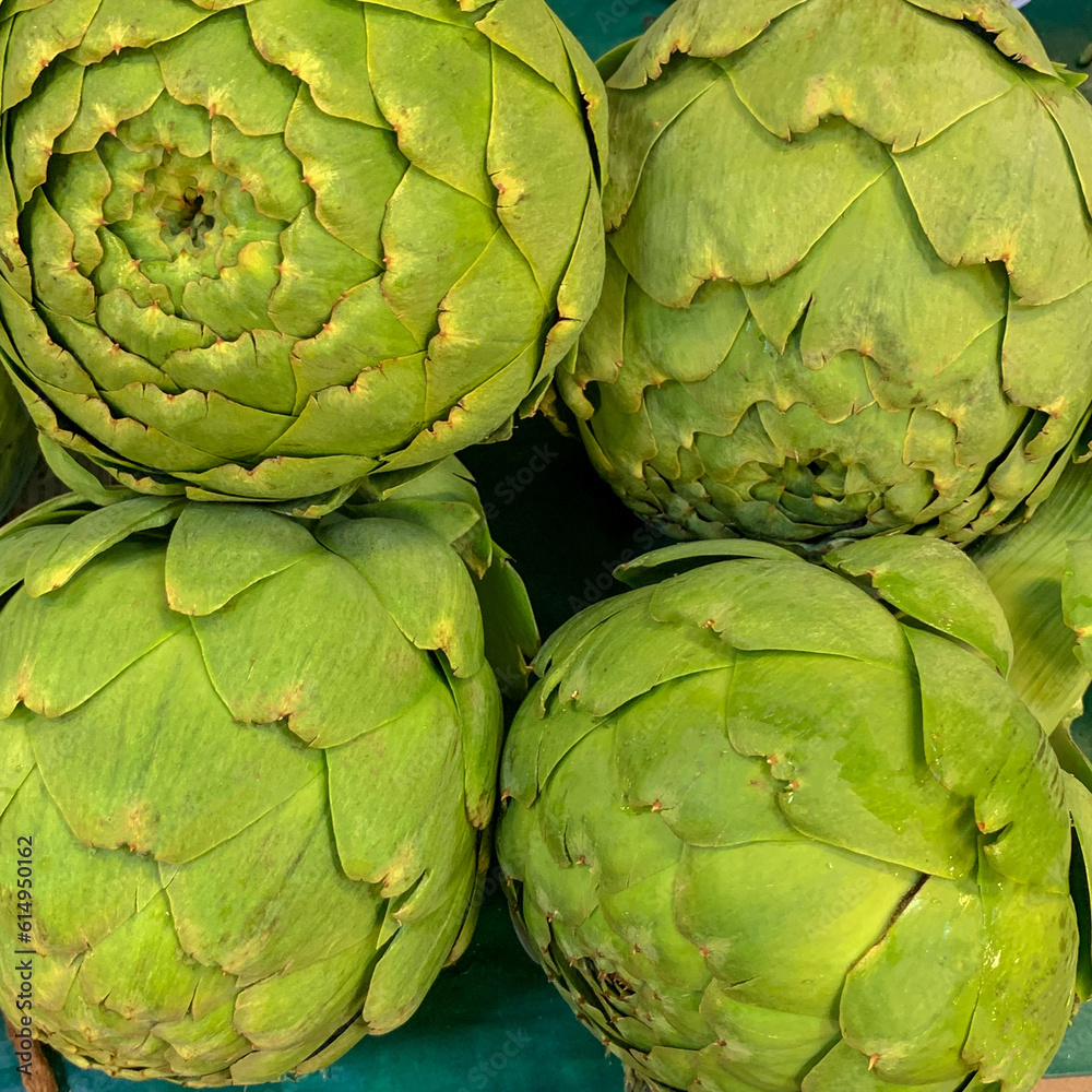 Fototapeta premium Fresh artichoke flower heads on market display.