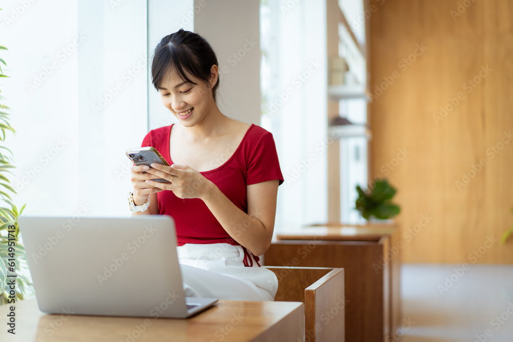 Beautiful Asian young woman working in co-working space in coffee shop by using laptop computer and smartphone. Concept of modern working lifestyle and work life balance. Beautiful Asian young woman working in co-working space in coffee shop by using laptop computer and smartphone. Concept of modern working lifestyle and work life balance.