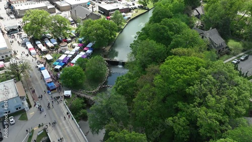 Aerial track backwards reveals Dogwood Festival booths and stalls during sunny day in Siloam Springs - Hyperlapse photo