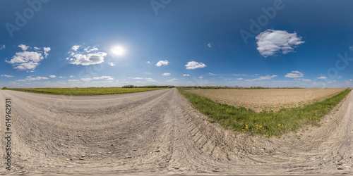 360 hdri panorama on gravel road with clouds and sun on blue sky in equirectangular spherical seamless projection, use as sky replacement in drone panoramas, game development sky dome or VR content