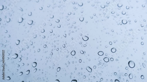 Rainwater drops Falling Down On the Window Glass, Rain Drops On The Windows Glass, and a Macro shot of water droplets falling. soft focus.shallow focus effect.
