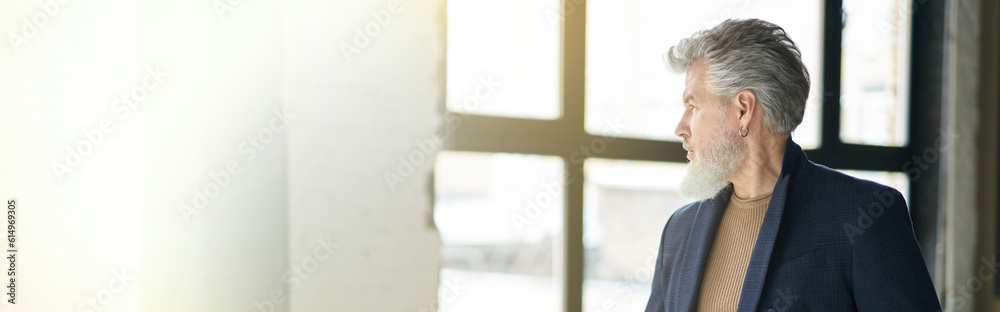 Stylish confident mature man looking aside while posing, leaning Stylish confident mature man looking aside while posing, leaning