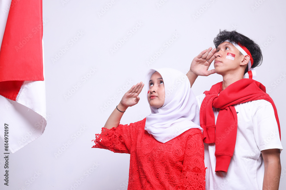 Side view of young Indonesian teenagers saluting Indonesia flag to ...