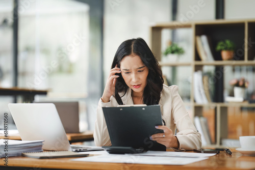 Financier a asian woman feel stress with works, uses a laptop, makes a report to a finance company. Accounting and financial concept