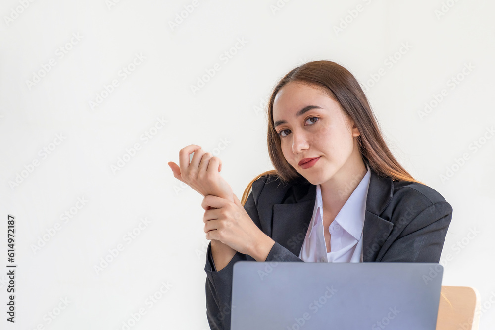 A successful business woman sitting in the office Using a laptop to work so hard that it hurts her wrists A successful business woman sitting in the office Using a laptop to work so hard that it hurts her wrists