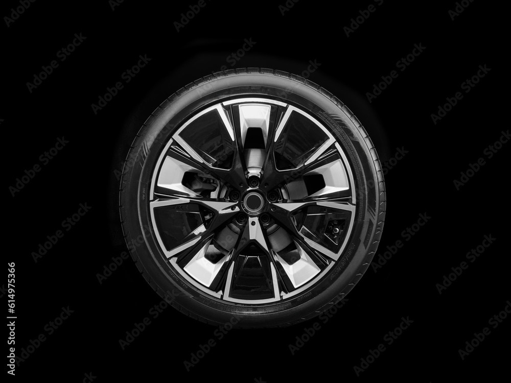 Car alloy wheel and tyre isolated on black background. New alloy wheel