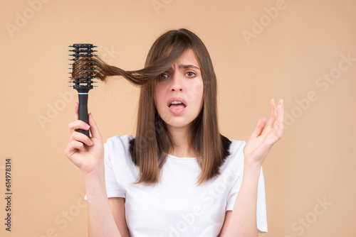 Sad girl with damaged hair. Hair loss problem treatment. Portrait of woman with a comb and problem hair.