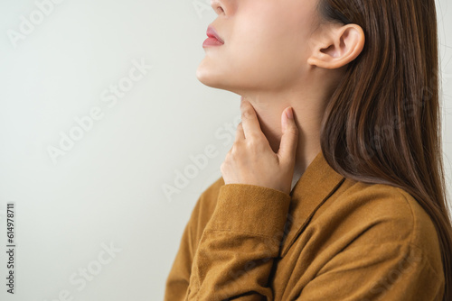 Canvas Print Sickness in inflaming asian young woman, girl use hand check self touch at sore throat, pain thyroid gland on neck or disease reflux, acid of suffer people on wall background