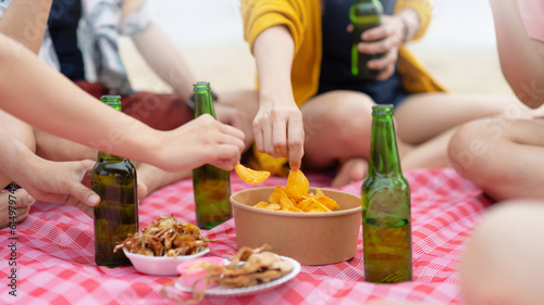 group of Happy young people with chips sharing with friends in  party at beach