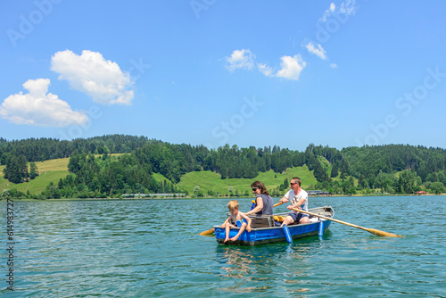 Familie hat Spass mit einem Ruderboot auf dem idyllischen Alpsee im Allgäu