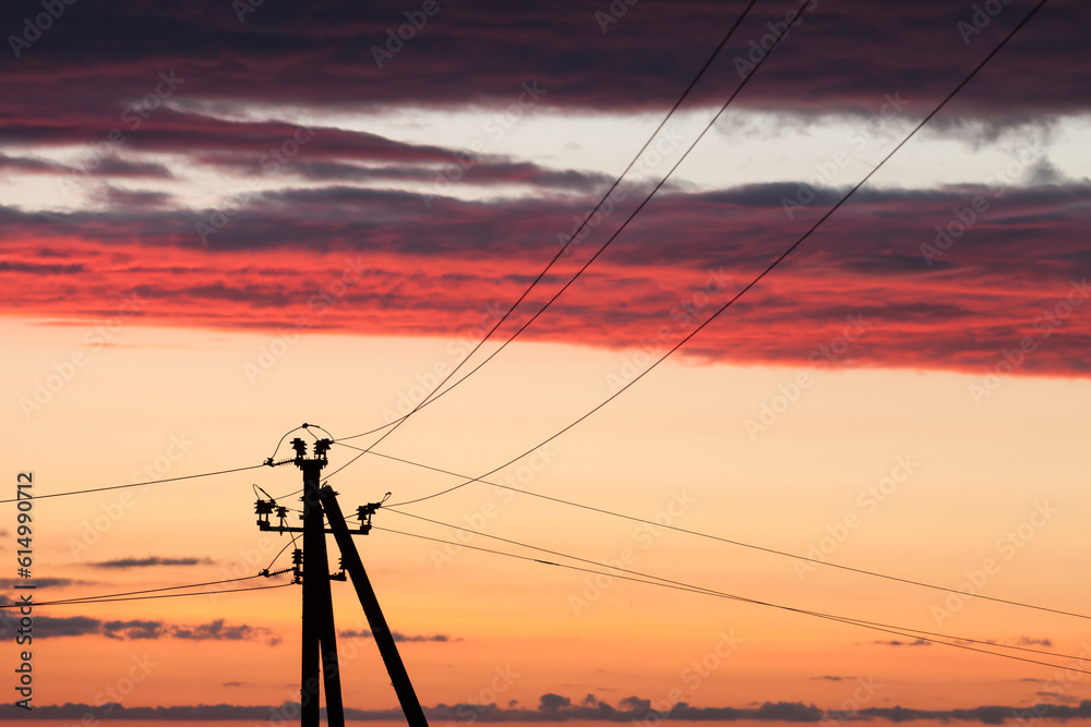 Electric line against colorful sky at sunset Electric line against colorful sky at sunset