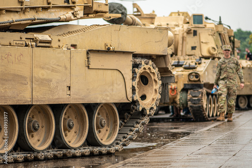 American United States Marine Corps soldier standing under the rain near an Abrams armoured tank, NATO response force photo