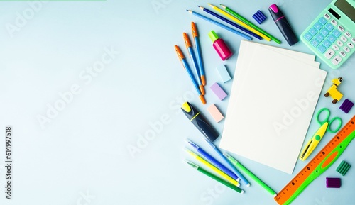 On a blue background, school supplies and office accessories, the concept of back to school, webinars, online learning, office work. Flat lay, top view. Copy space for text, space, banner.