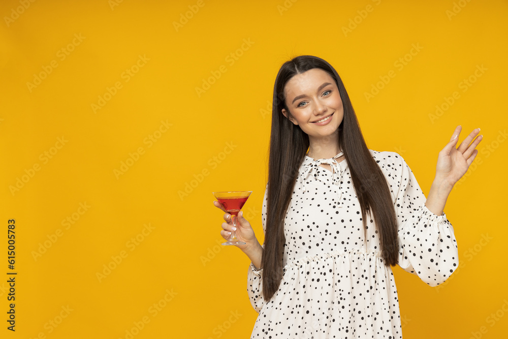 Young woman with a cocktail on a yellow background Young woman with a cocktail on a yellow background
