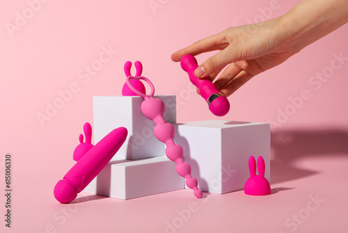 Composition of pink sex toys with cubes on a pink background